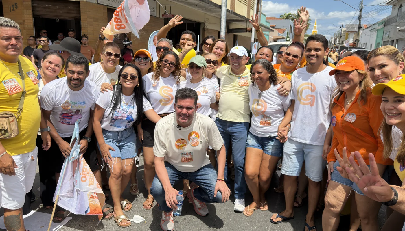 Roger Aguiar agachado em meio a apoiadores na rua